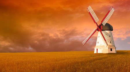 Wind white windmill in a field at sunset.の写真素材