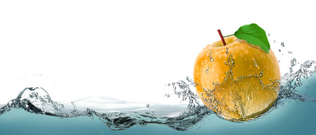 Yellow, juicy apple as a card on the water background.の写真素材
