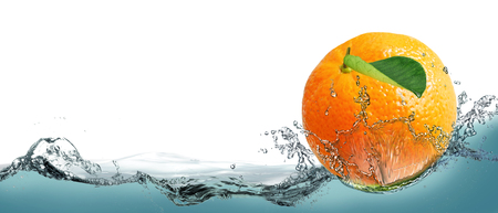 The fruit of a ripe tangerine on a background of splashing water.の写真素材