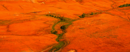 Rural hilly terrain painted red from the sunset.の写真素材