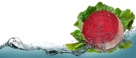 Red beet with water splash isolated on white.の写真素材