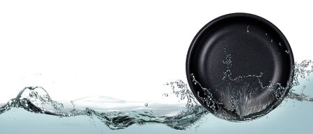 Black plate in spray of water on a white background.の写真素材
