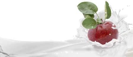 Ripe, red apple in a splash of yogurt.の写真素材
