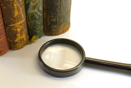 closeup of old books from an antiquarian bookshop with magnifierの写真素材