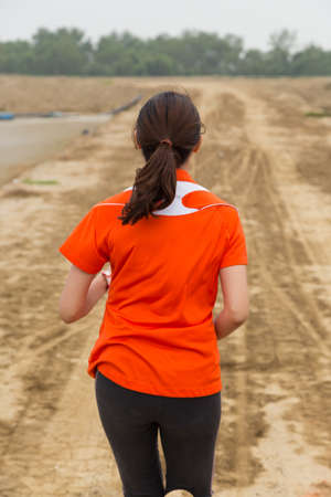young woman running on mountain trail with white backgroundの写真素材