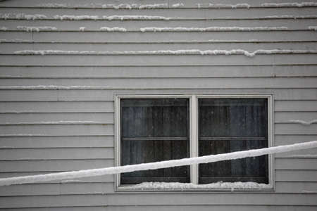 Snow on s House - Winter snow accumulates on the side of a suburban house.の写真素材