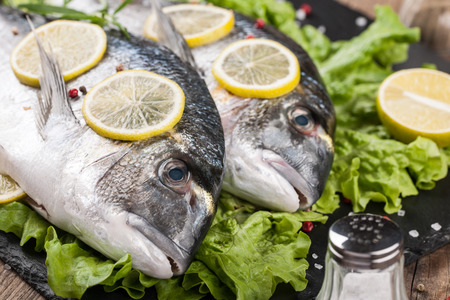 Raw fresh fish dorado on cutting boardの写真素材