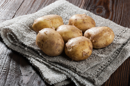 Raw potatoes on wooden tableの写真素材