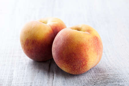 Ripe peaches on wooden table close-upの写真素材