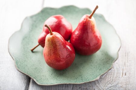 Two ripe pears on the green plate on wooden tableの写真素材