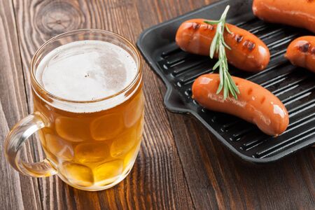 Grilled sausages and beer on wooden tableの写真素材