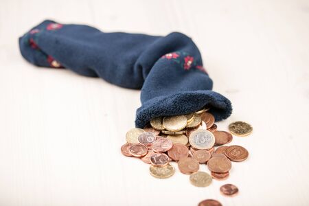 Euro coins in the sock and on wooden tableの写真素材