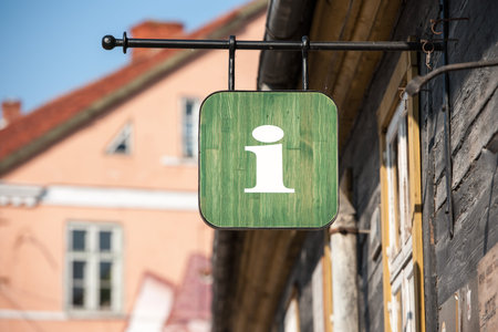 Green wooden tourist information office sign in small town