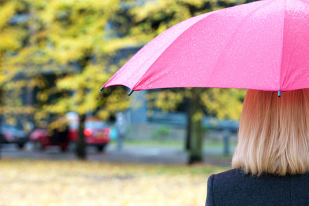 Woman with umbrella on autumn backgroundの写真素材