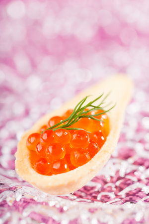 Tartlet with red caviar on glass plateの写真素材