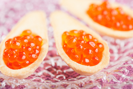 Tartlets with red caviar on glass plateの写真素材
