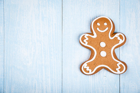 Christmas man-shaped cookie gingerbread on blue wooden background