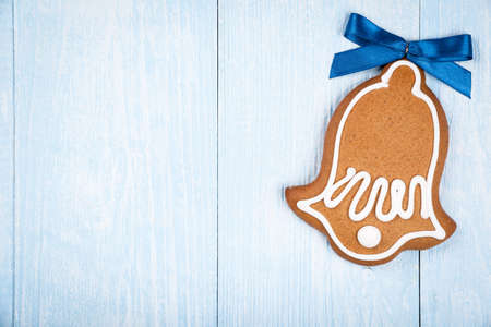 Christmas bell-shaped cookie gingerbread on blue wooden backgroundの写真素材