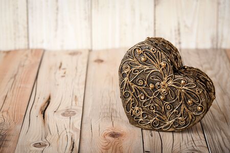 Gift box heart shaped on wooden boards, toned photoの写真素材