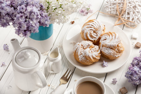 Coffee and profiteroles on wooden table