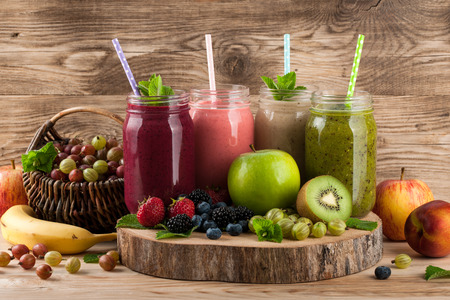 Smoothies, fruits and berries on wooden backgroundの写真素材