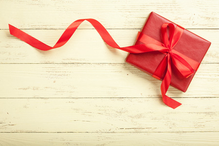 Red gift box on yellow wooden backgroundの写真素材