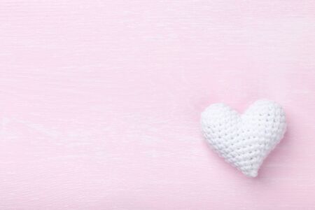 Crochet white heart on pink wooden backgroundの写真素材