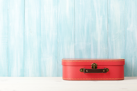 Travel concept with retro style suitcase on blue wooden backgroundの写真素材