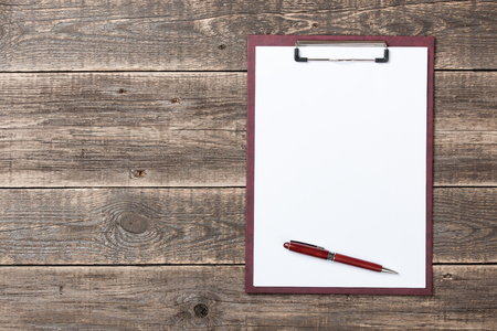Clipboard and pen on wooden deskの写真素材