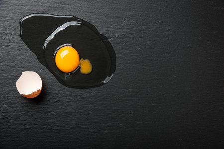 Broken egg on black stone
