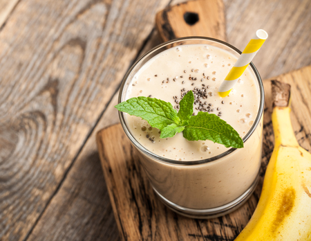 Banana smoothie glass on wooden tableの写真素材