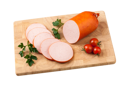 Sausage with tomatoes and herbs on chopping board on whiteの写真素材