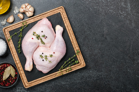 Raw chicken legs  on cutting boardの写真素材
