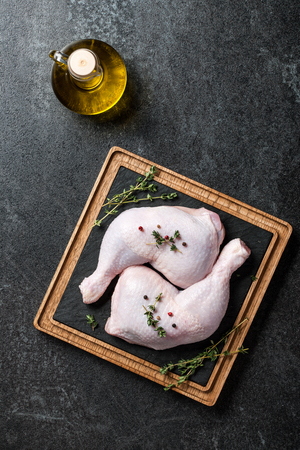 Raw chicken legs  on cutting boardの写真素材