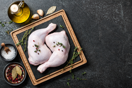 Raw chicken legs  on cutting boardの写真素材