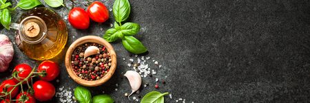Fresh tomatoes, spices and basil leaves on black backgroundの写真素材