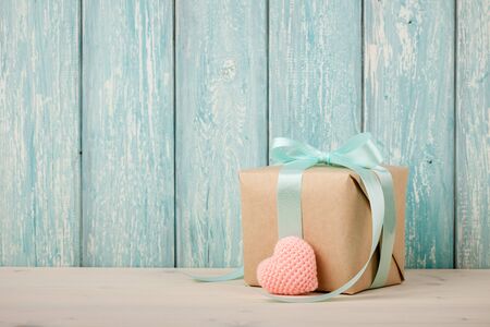Gift box and crochet heart on blue wooden backgroundの写真素材