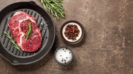 Fresh ribeye steak on a pan and spicesの写真素材