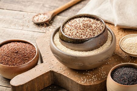 White, red, black and mixed quinoa on wooden tableの写真素材