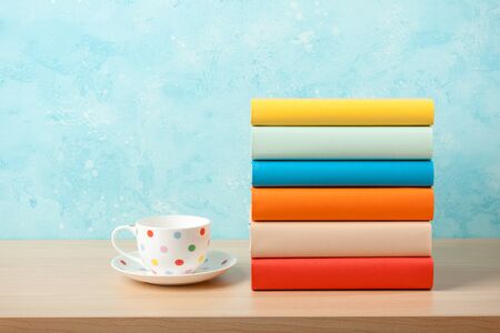Stack of books and mug on wooden tableの写真素材