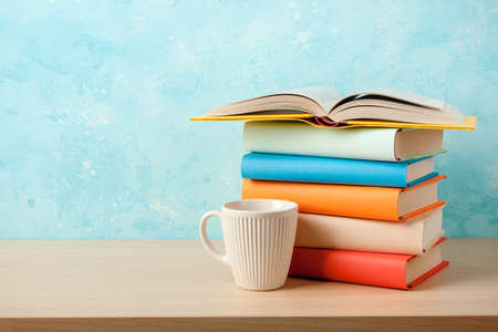 Stack of books and mug on wooden tableの写真素材