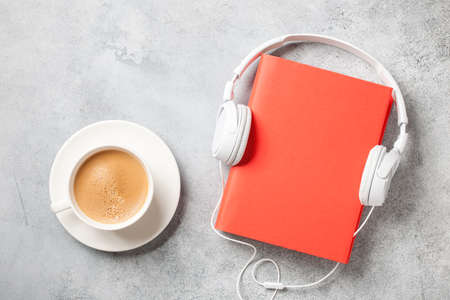 Headphones, book and cup of coffee on concrete surfaceの写真素材
