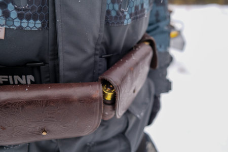 Hunting gear in the hands of a man in a winter forest