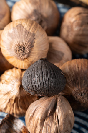 Close up of Black Garlic on a wooden table. Selective focus.の写真素材