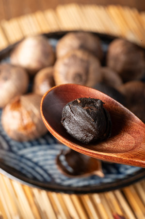 Dried garlic in a wooden spoon on a wooden background. Selective focus.の写真素材