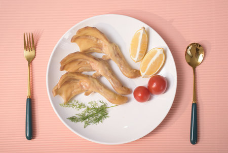 Fried chicken fillet with lemon and dill on a white plateの写真素材