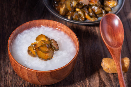 Rice porridge with pork and eggplant in wooden bowl.の写真素材