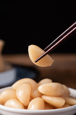 Japanese food, boiled garlic in a bowl with chopsticks on a black backgroundの写真素材