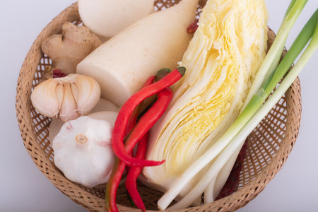 garlic and vegetables in bamboo basketの写真素材