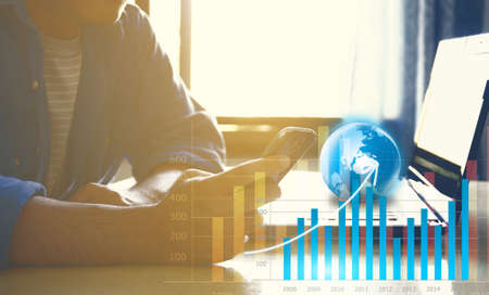 Hand touch screen smart phone. financial graphの写真素材